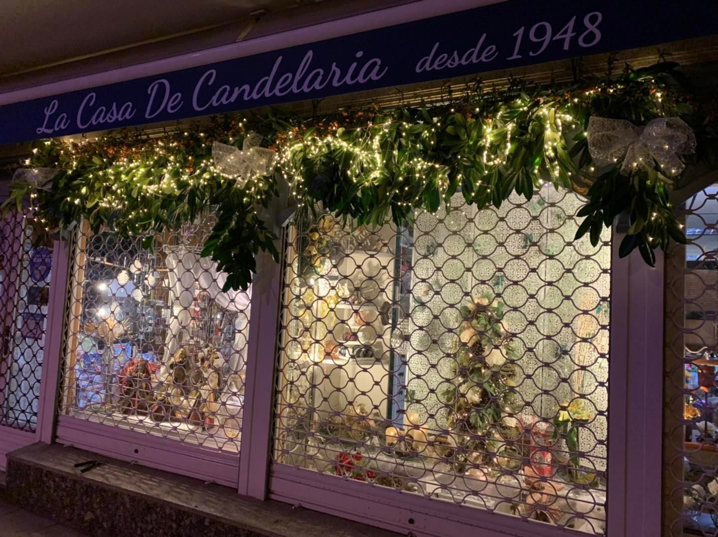 Escaparate de tienda con luces y decoración navideña; 