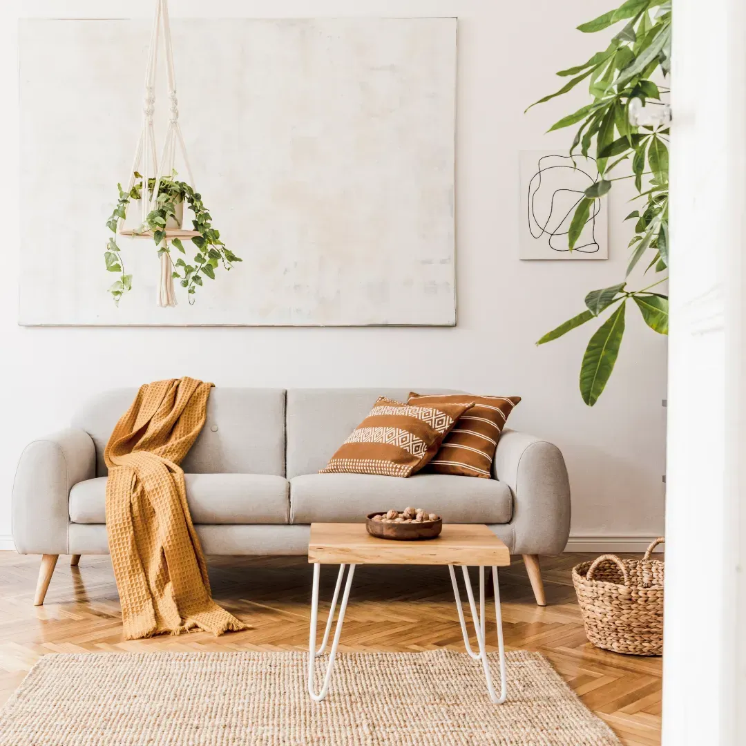 Una sala de estar con un sofá, una mesa, una alfombra y un cuadro en la pared.