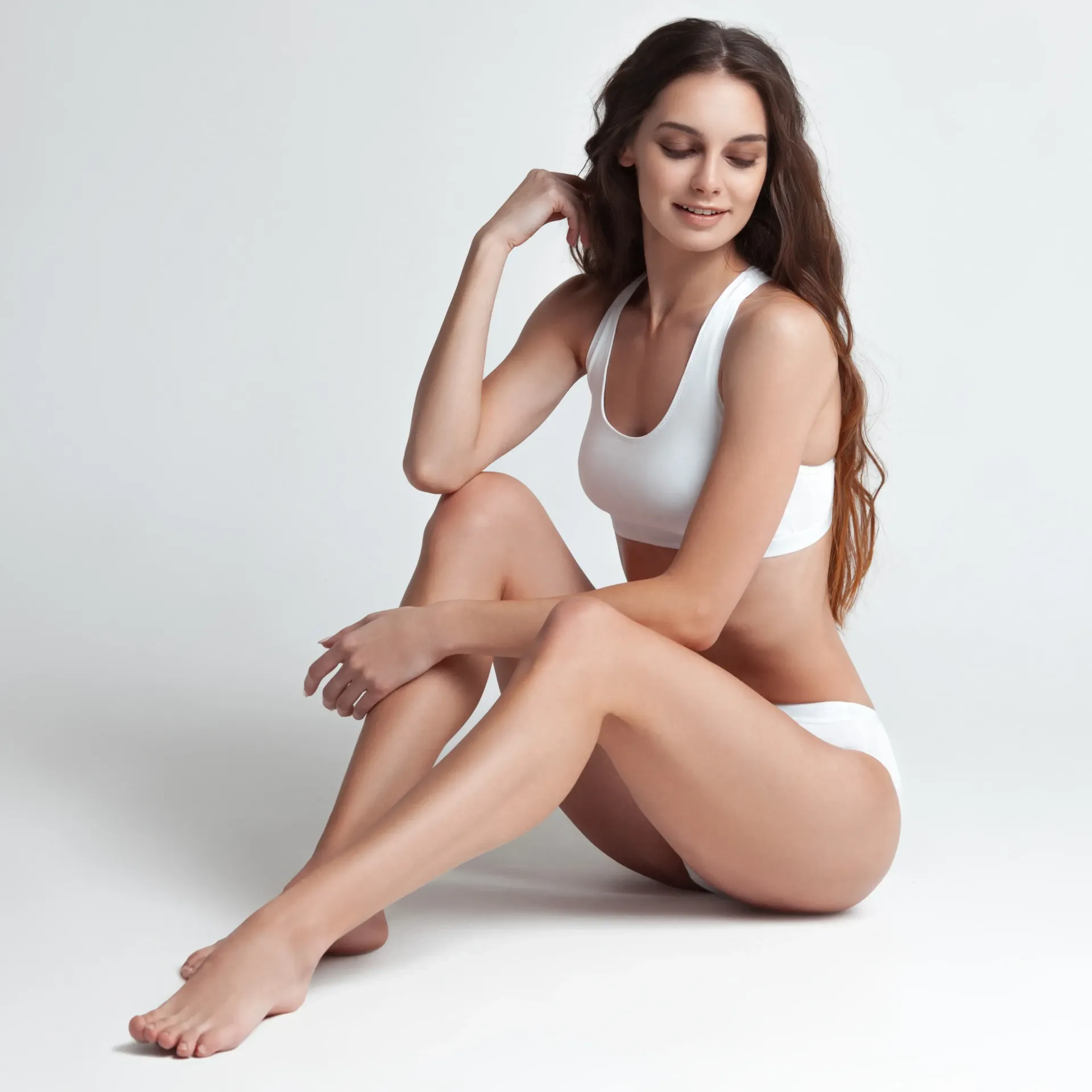 Peluquero peinando el cabello de una clienta con una plancha en un salón.
