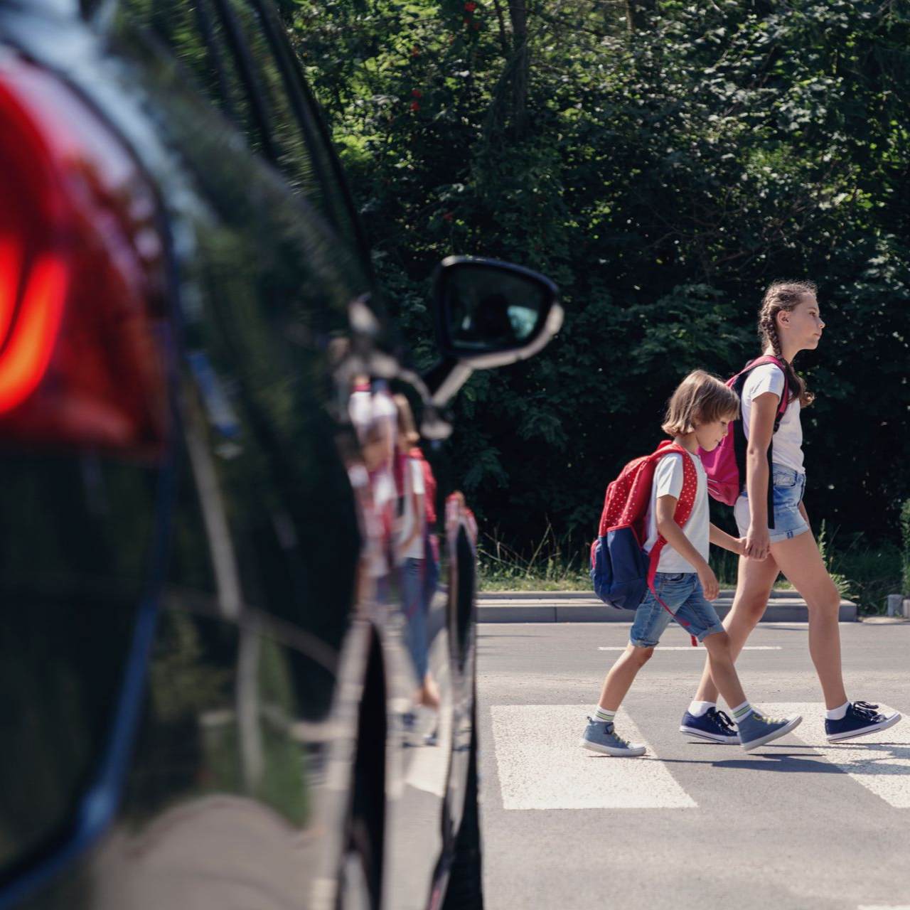Enfants traversant une route devant une voiture