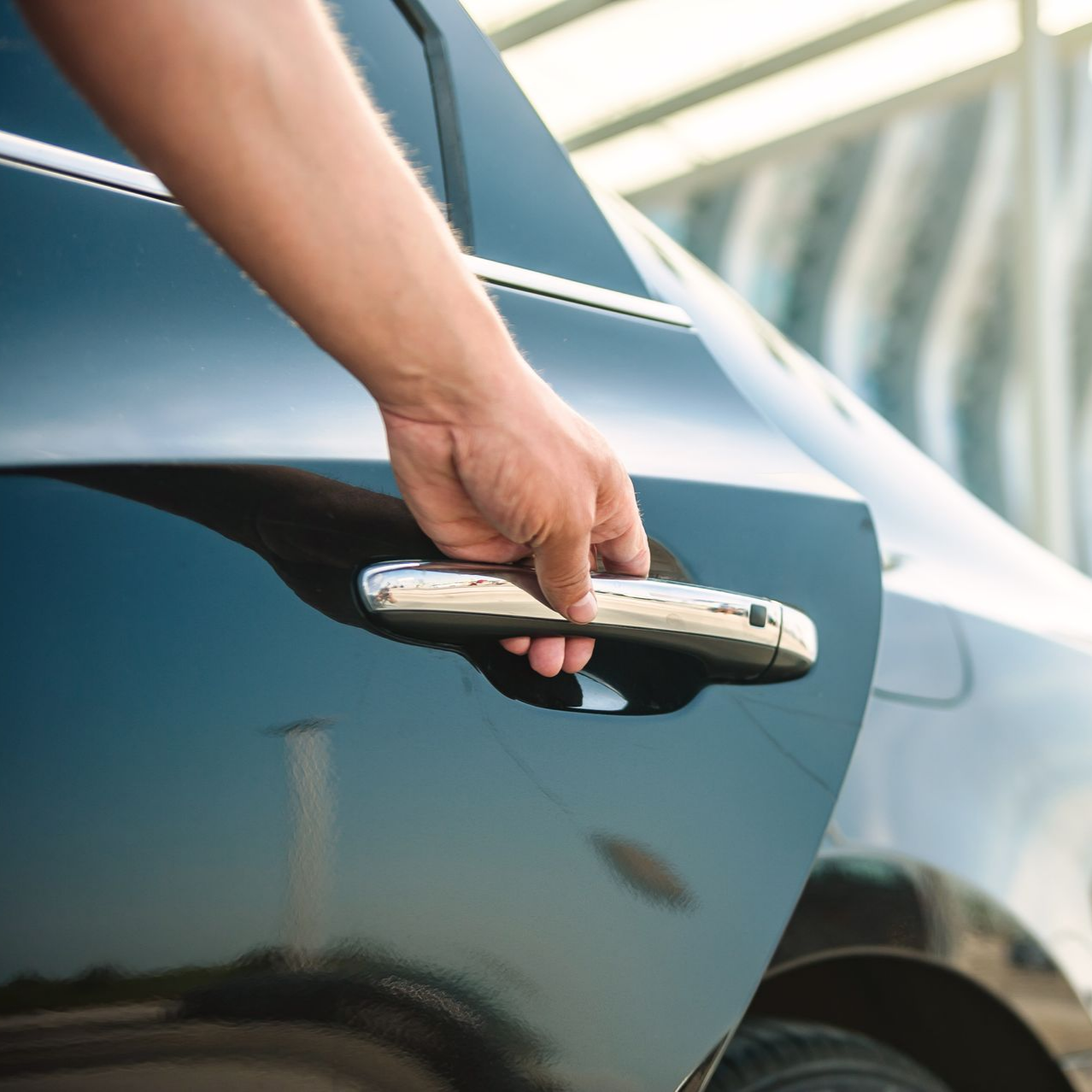 Chauffeur de taxi ouvrant la porte arrière de sa voiture