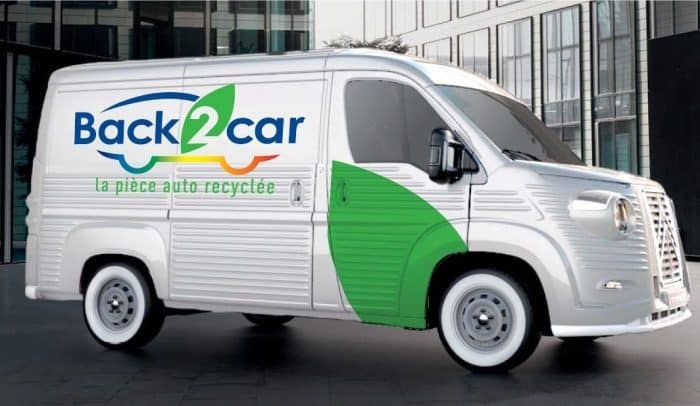 Fourgon blanc de transport avec le logo de recyclage « Back2car » et des motifs verts, stationné en extérieur
