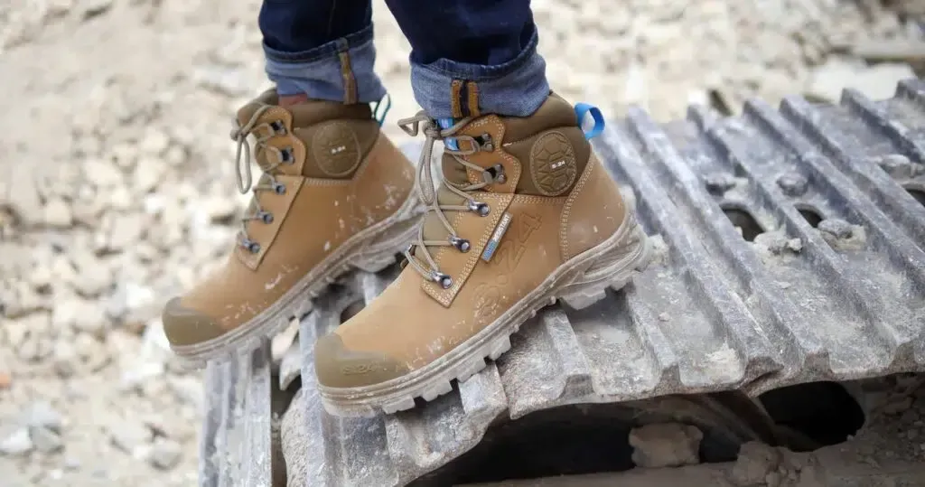 Des chaussures de sécurité marron posées sur une surface métallique ondulée en extérieur