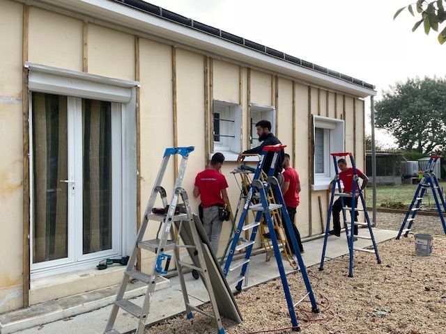 Équipes de Isotop 44 en train de monter un bardage sur un chantier