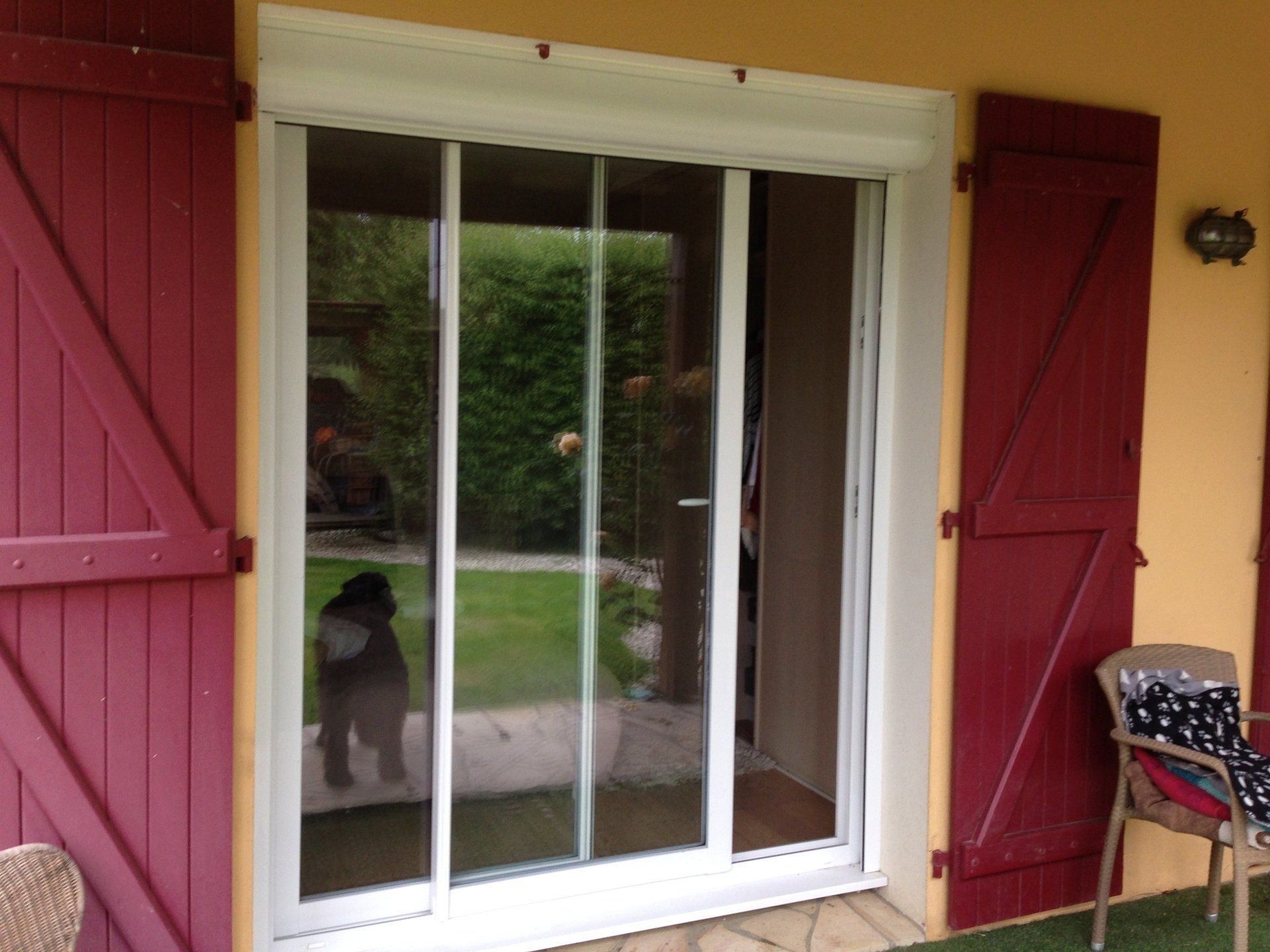 Porte fenêtre coulissante avec volets rouges