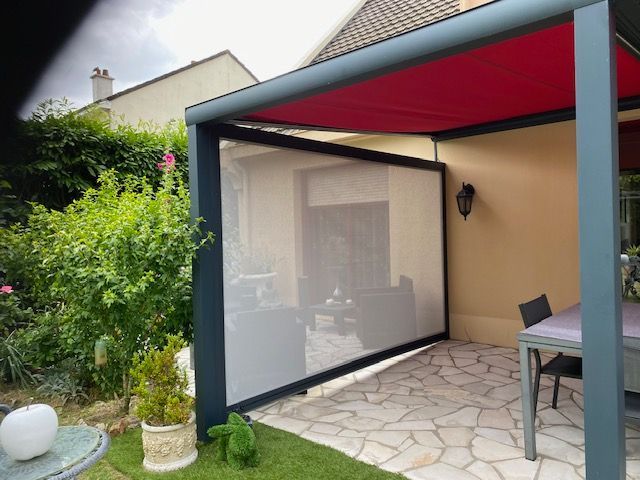 Pergola noire métallisée avec un store rouge