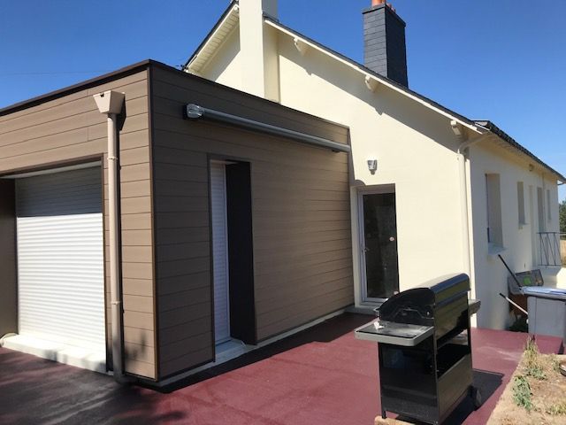 Patio de maison moderne avec extérieur marron et crème, porte sectionnelle, barbecue et allée pavée rouge