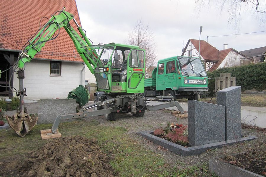 Minibagger in Aktion auf einem Friedhof