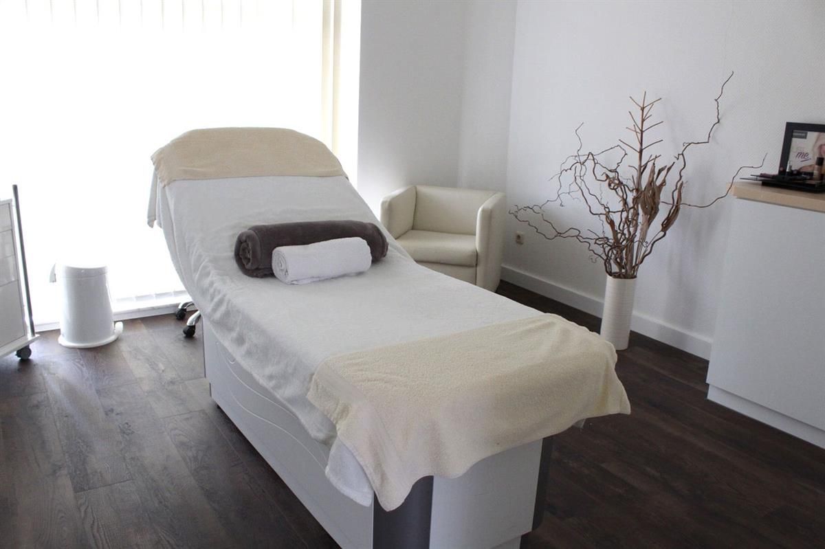 Eine Massageliege in einem Raum mit einem Stuhl