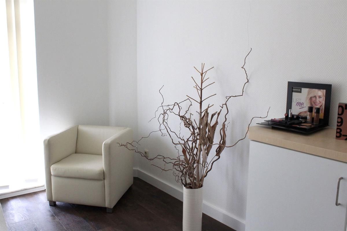 Ein Raum mit einem Stuhl und einer Vase mit einem Bild einer Frau darauf