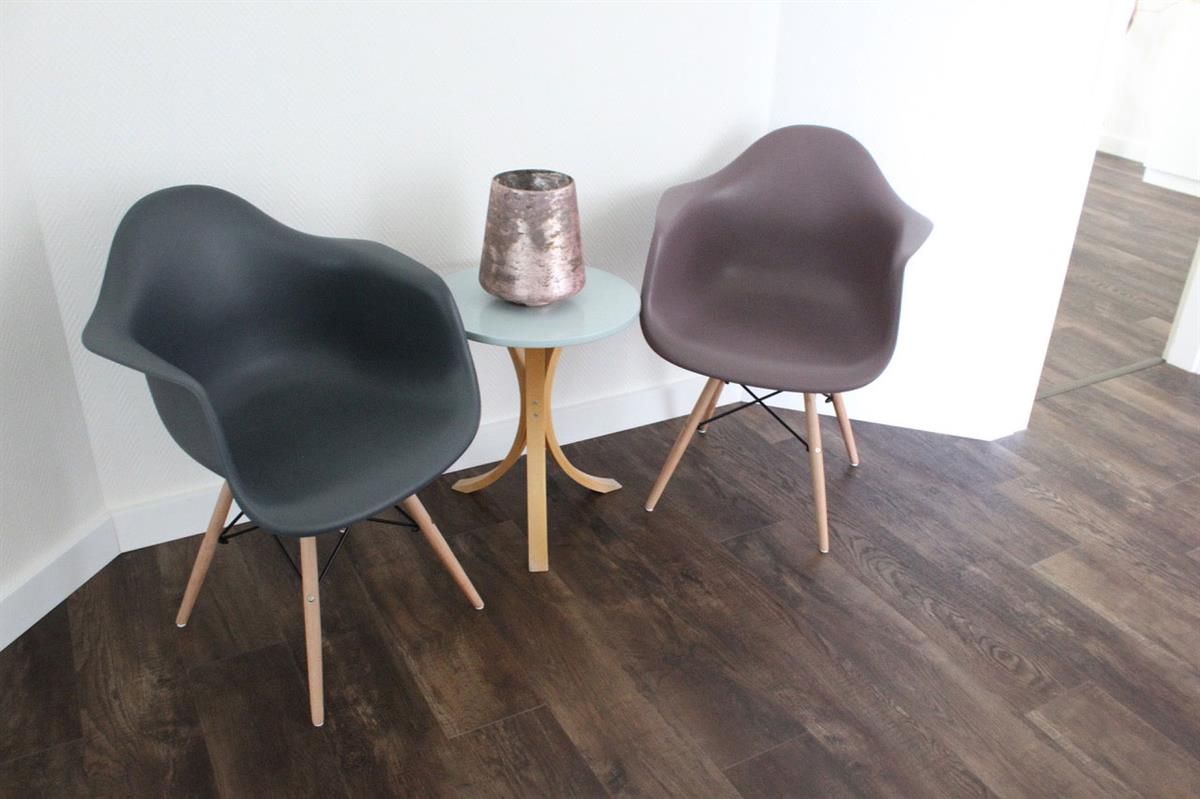 Neben einem kleinen Tisch stehen zwei Stühle, auf denen eine Vase steht.