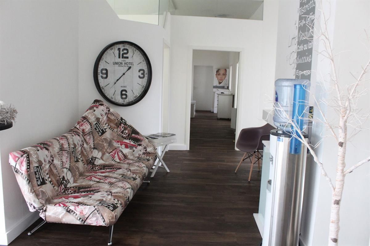 Ein Wohnzimmer mit einer Couch und einer Uhr an der Wand