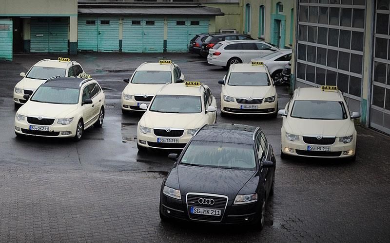 Eine Gruppe von Taxis steht auf einem Parkplatz