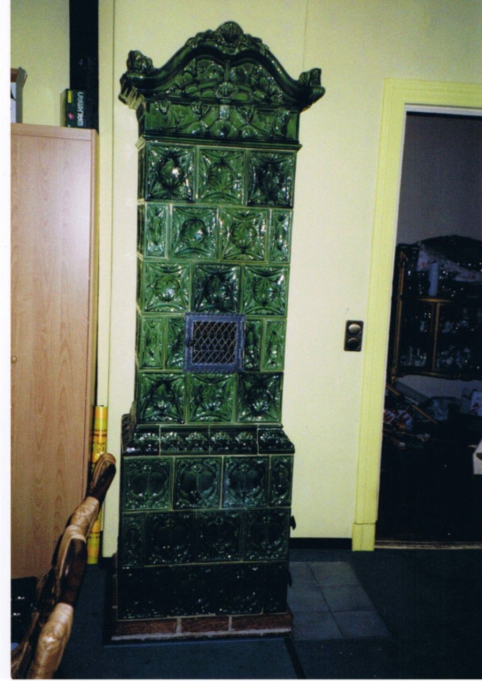 Kachelofen schmal und hoch aus dunkelgrünen Kacheln, antiker Stil