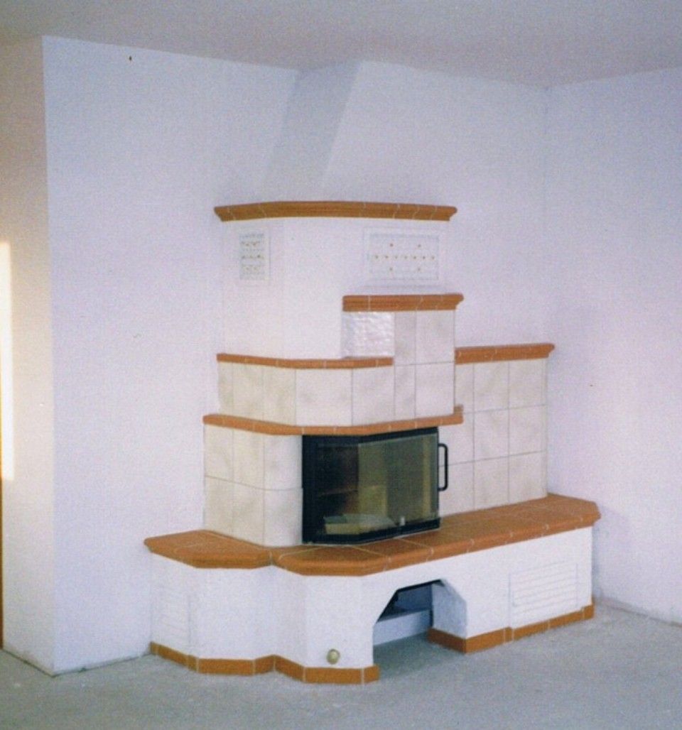 moderner Kachelofen in weiß und Terrakotta mit sichtbarer Feuerstelle mit Sicherheitsglas