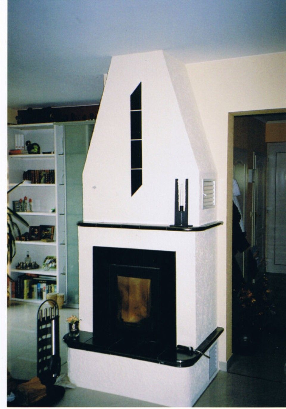 Kamin im modernen Stil passt farblich perfekt zur Wand mit sichtbarer Feuerstelle