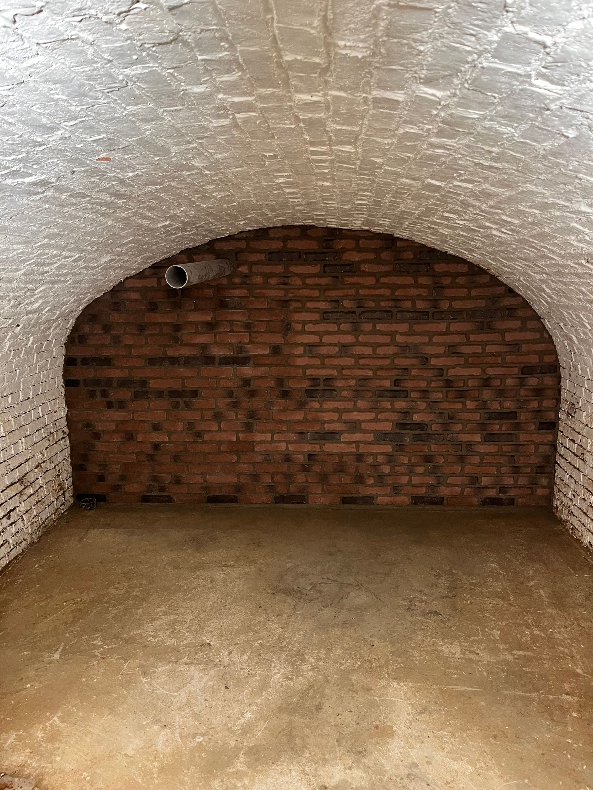 Pièce voûtée en briques avec un sol en béton.