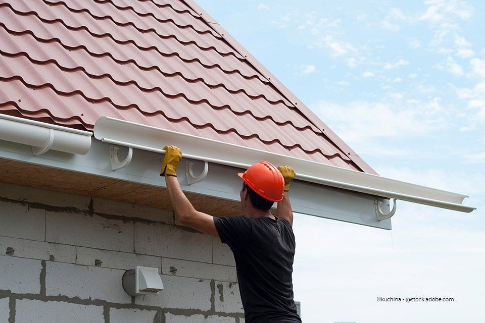 Bauklempner installiert eine Regenrinne an einem Dach