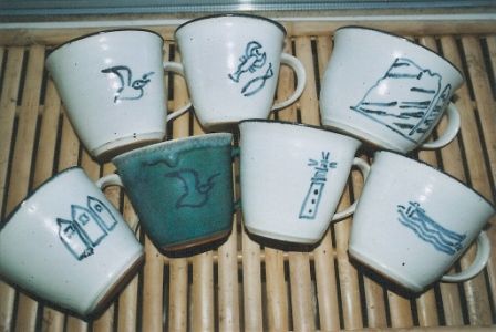 Eine Gruppe von Kaffeetassen mit verschiedenen Motiven darauf