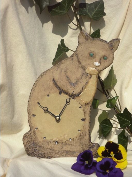 Eine Uhr in Form einer Katze, die auf einem Tisch sitzt