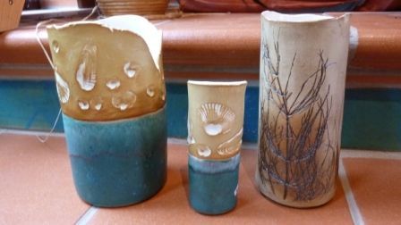 Drei Keramikvasen stehen auf einem gefliesten Boden.