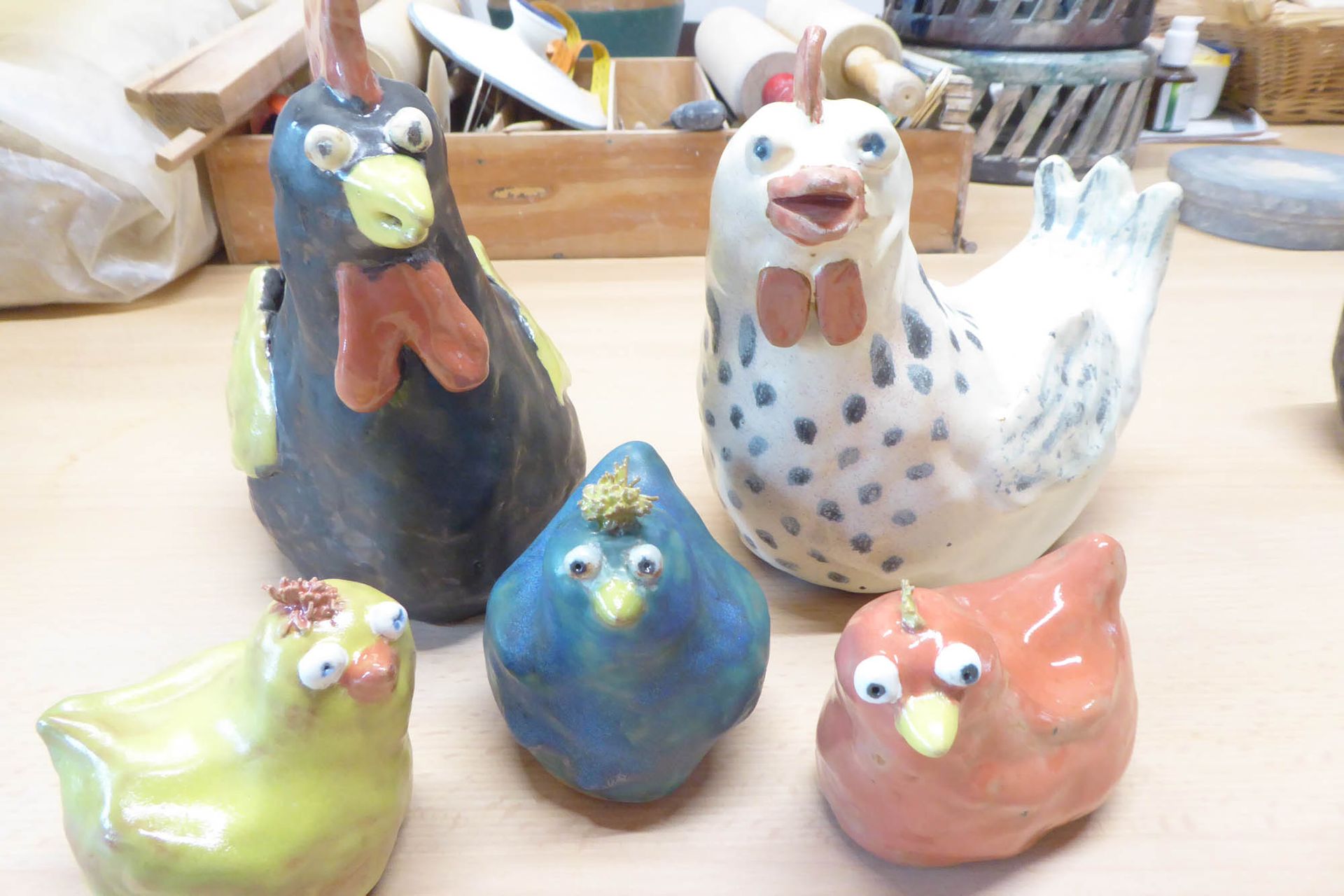 Eine Gruppe Keramikhühner sitzt auf einem Tisch