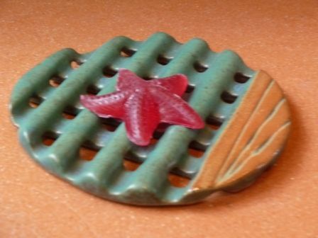 Ein roter Seestern sitzt auf einem grünen Teller