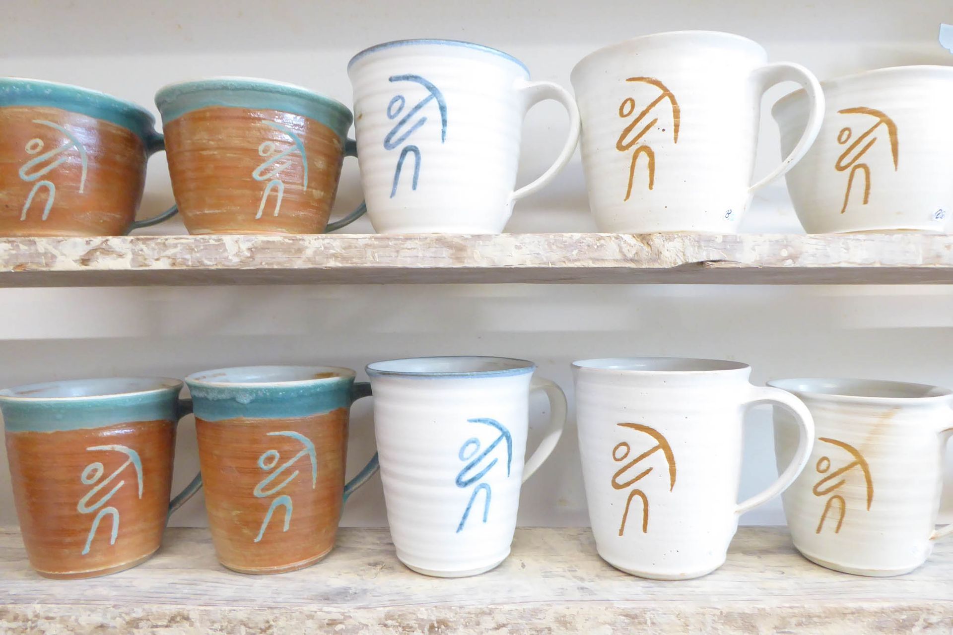 Eine Reihe von Kaffeetassen auf einem Regal mit dem Wort Liebe darauf