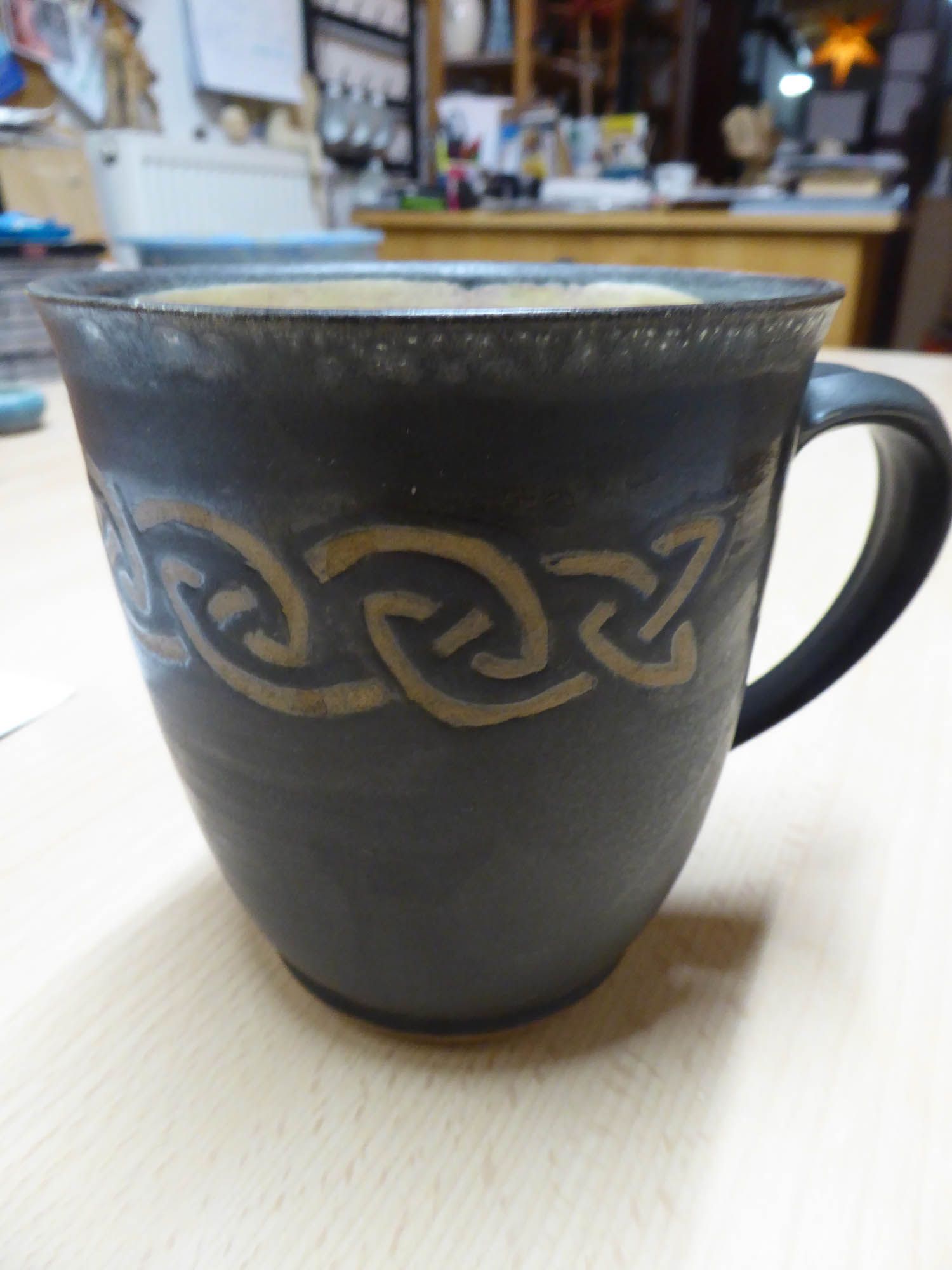 Eine schwarze Tasse mit keltischem Motiv