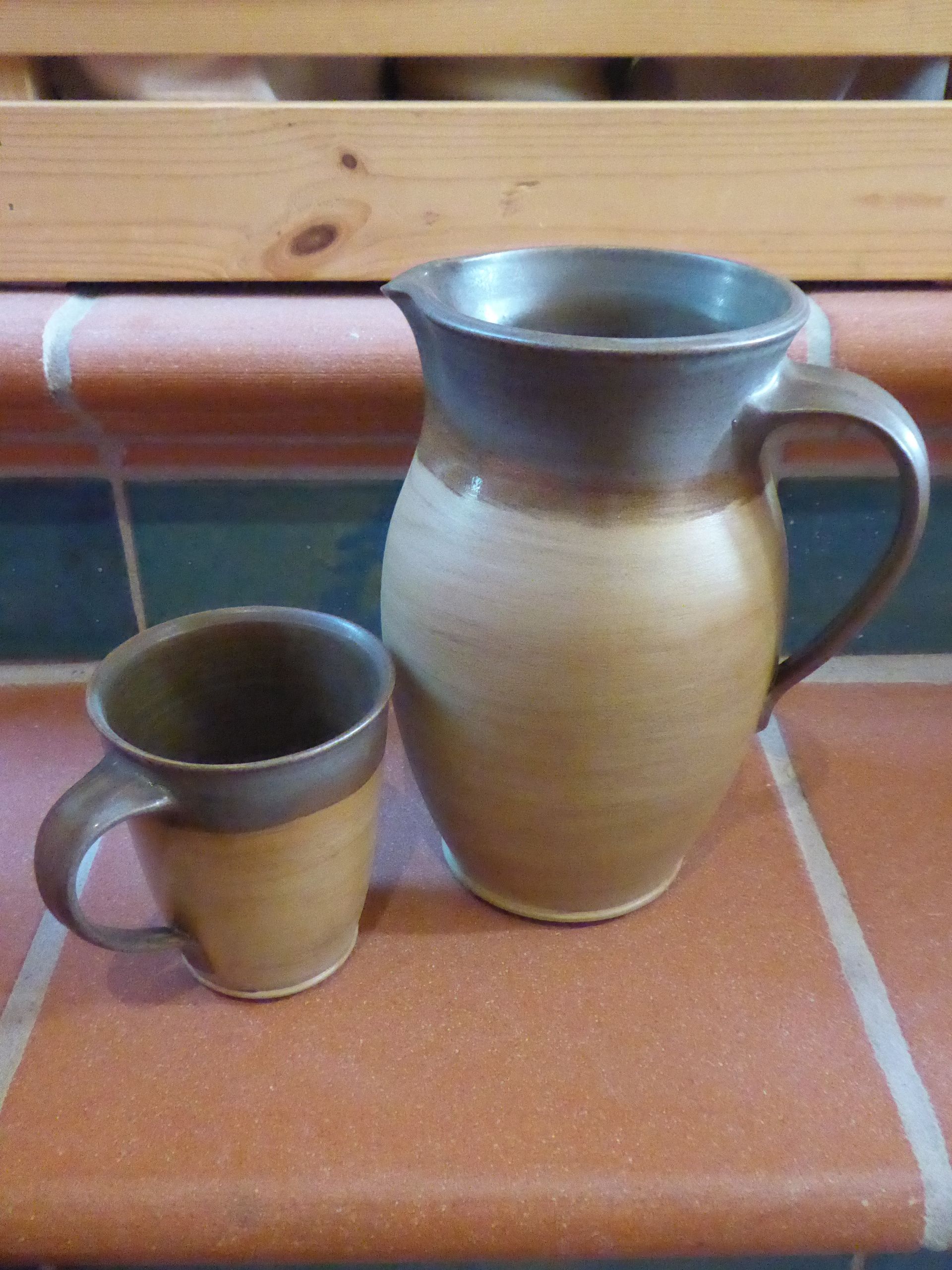 Ein Krug und eine Tasse stehen auf einer gefliesten Arbeitsplatte