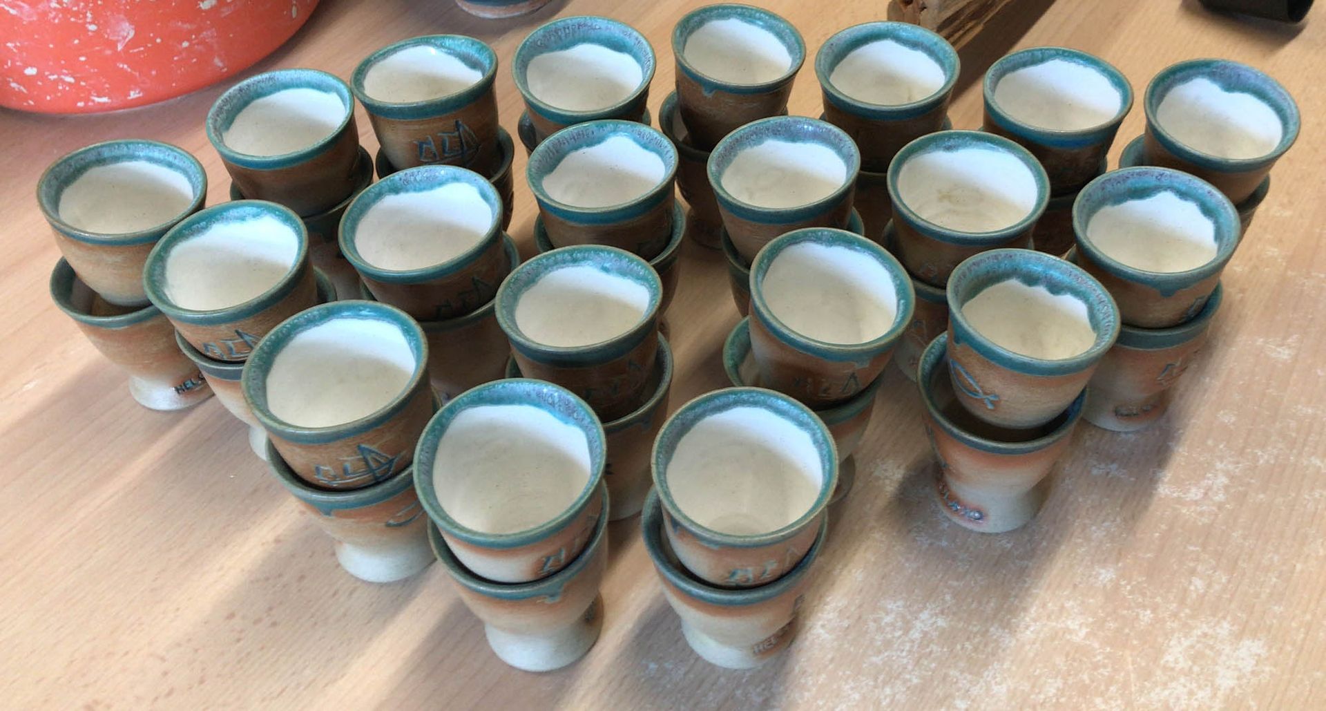 Auf einem Tisch sind mehrere Schnapsgläser übereinander gestapelt.