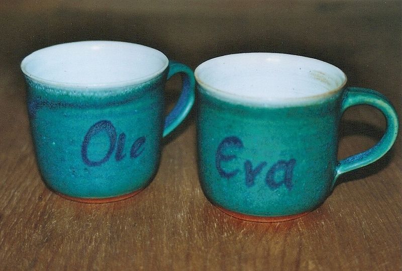 Zwei grüne Tassen mit den Namen Ole und Eva darauf