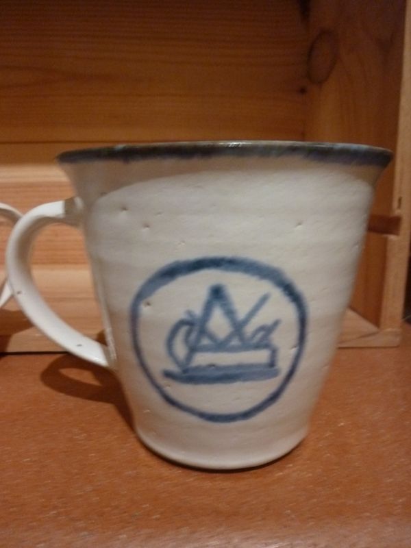 Eine weiße Tasse mit einem blauen Logo darauf