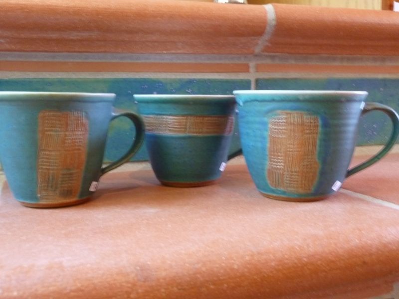 Drei blaue Tassen stehen auf einer gefliesten Theke