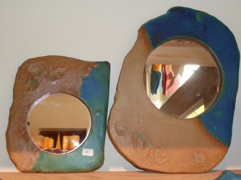 Zwei Spiegel stehen auf einem Regal und einer hat ein Preisschild daran