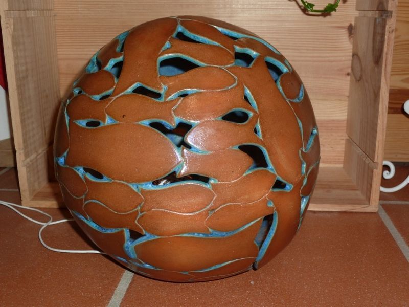 Ein brauner Ball mit einem blauen Muster liegt auf einem gefliesten Boden