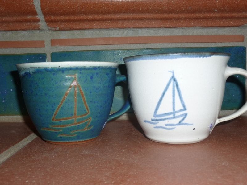 Zwei Tassen mit aufgemalten Segelbooten