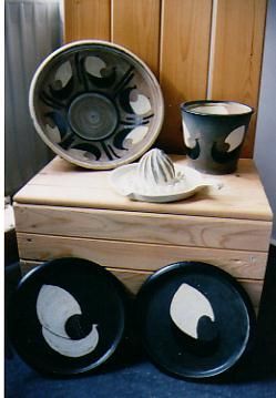 Eine Holzkiste gefüllt mit schwarzen und weißen Tellern und Schüsseln.
