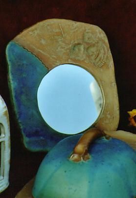 Auf einem blauen Kürbis sitzt ein Spiegel.