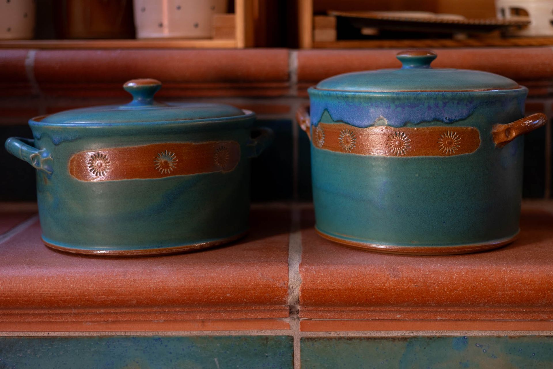 Auf einer gefliesten Arbeitsplatte stehen zwei Töpfe.