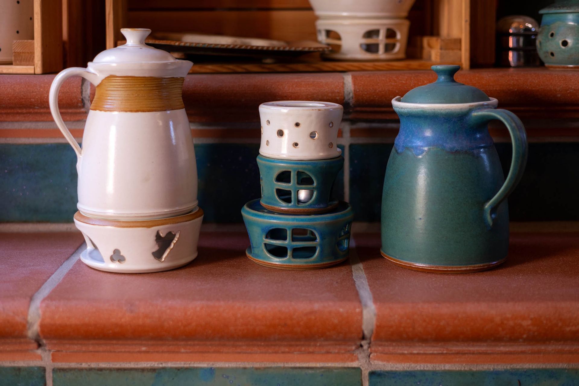 Eine Gruppe von Keramiktöpfen steht auf einer gefliesten Arbeitsplatte