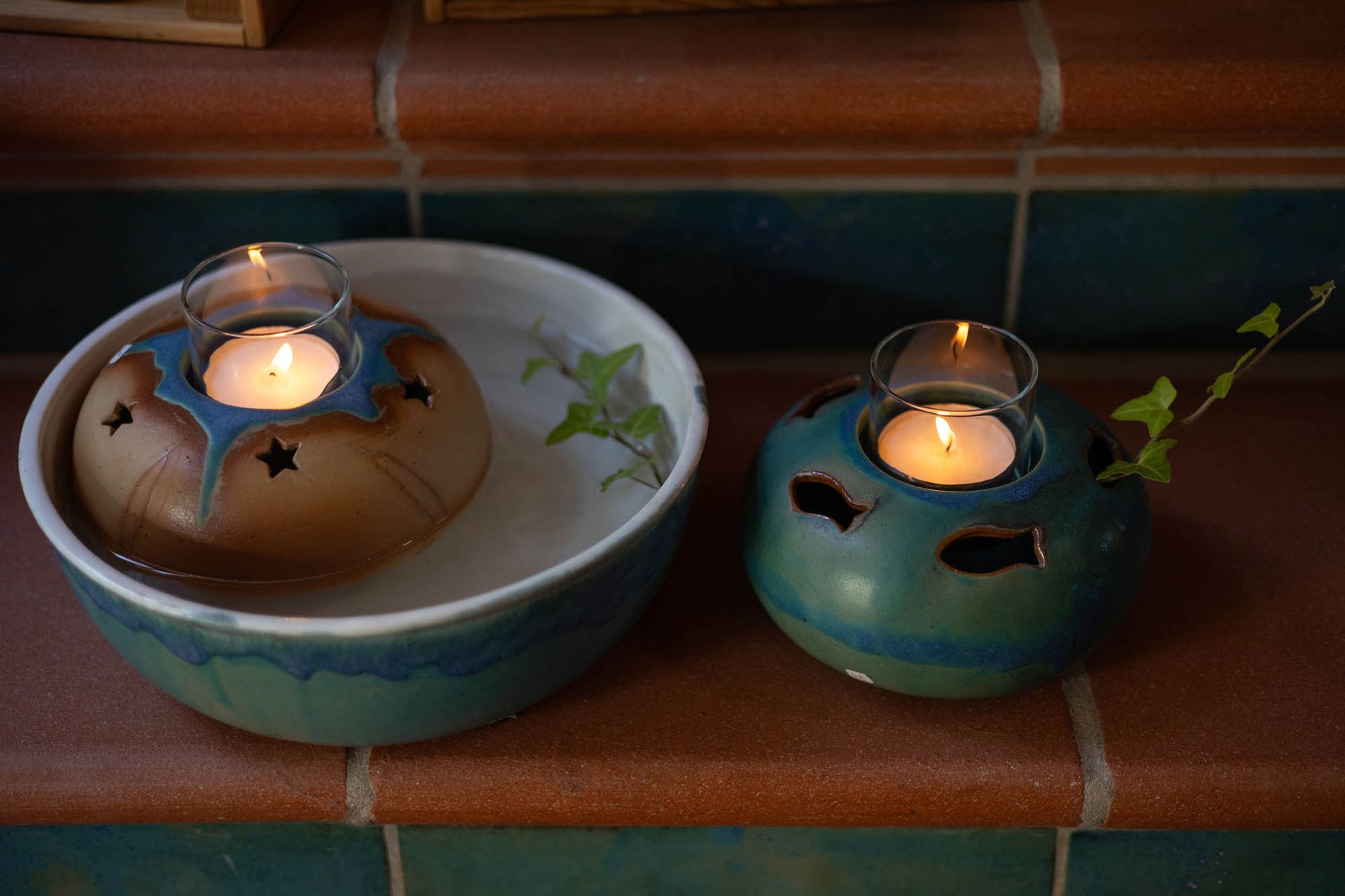 Zwei Kerzenständer stehen nebeneinander auf einem Tisch.