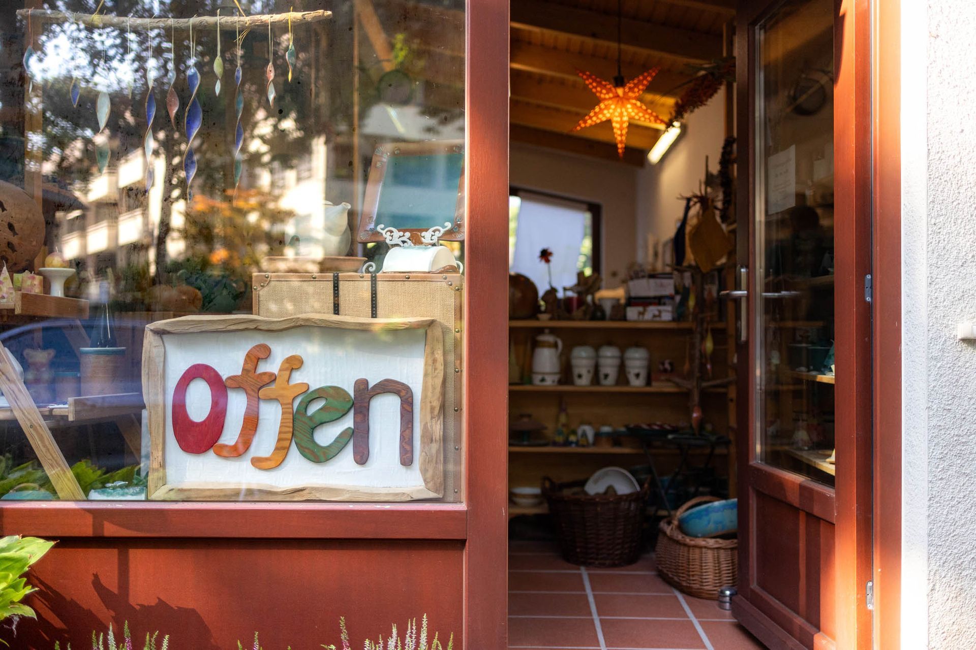 Eine Ladenfront mit einem Schild mit der Aufschrift „Geöffnet“.