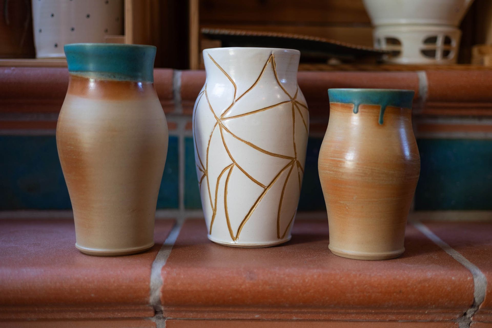Drei Vasen stehen auf einem gemauerten Regal.