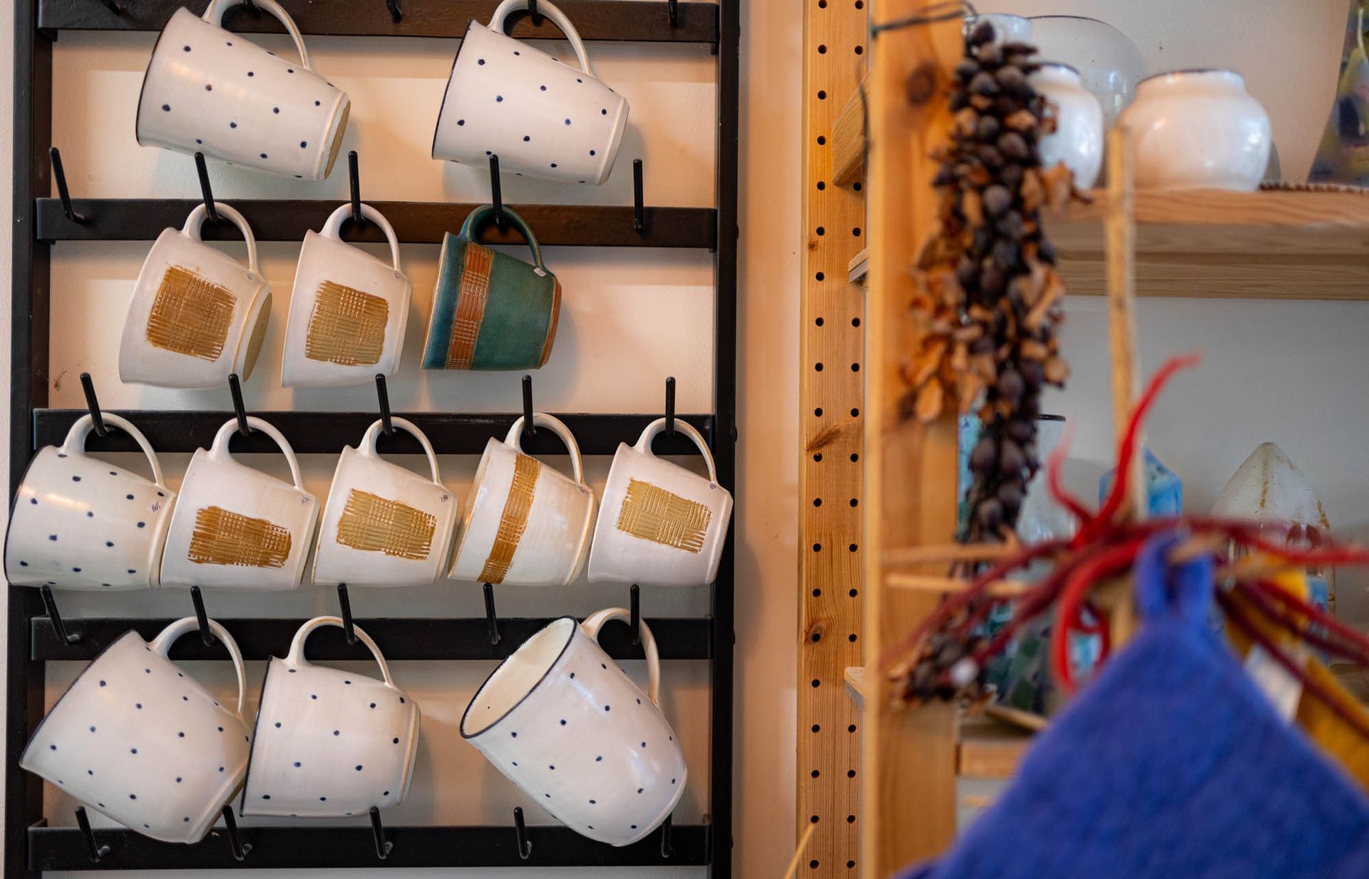 An einer Wand hängt ein Regal mit Kaffeetassen.