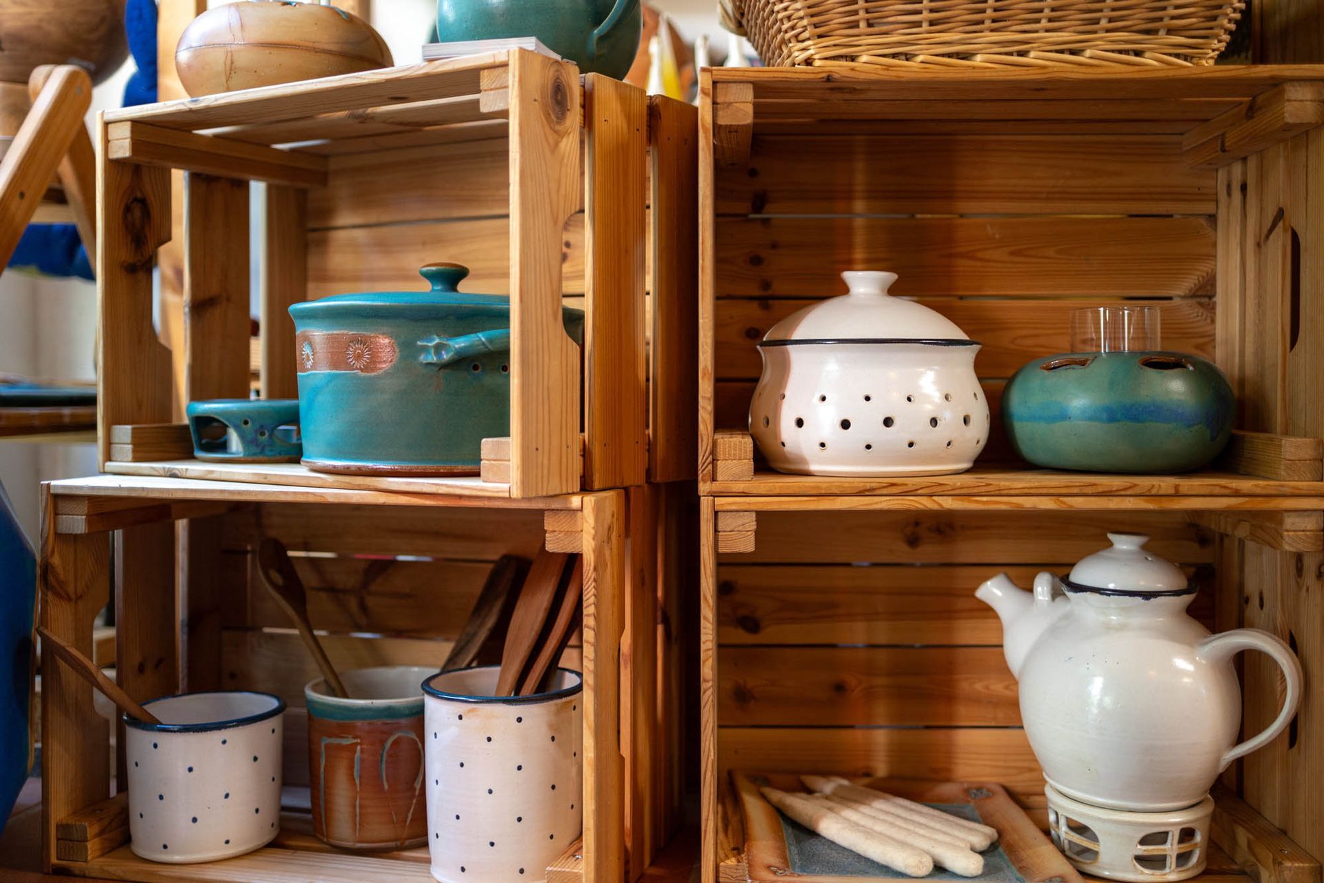 Ein Holzregal mit Töpfen und Pfannen darauf.