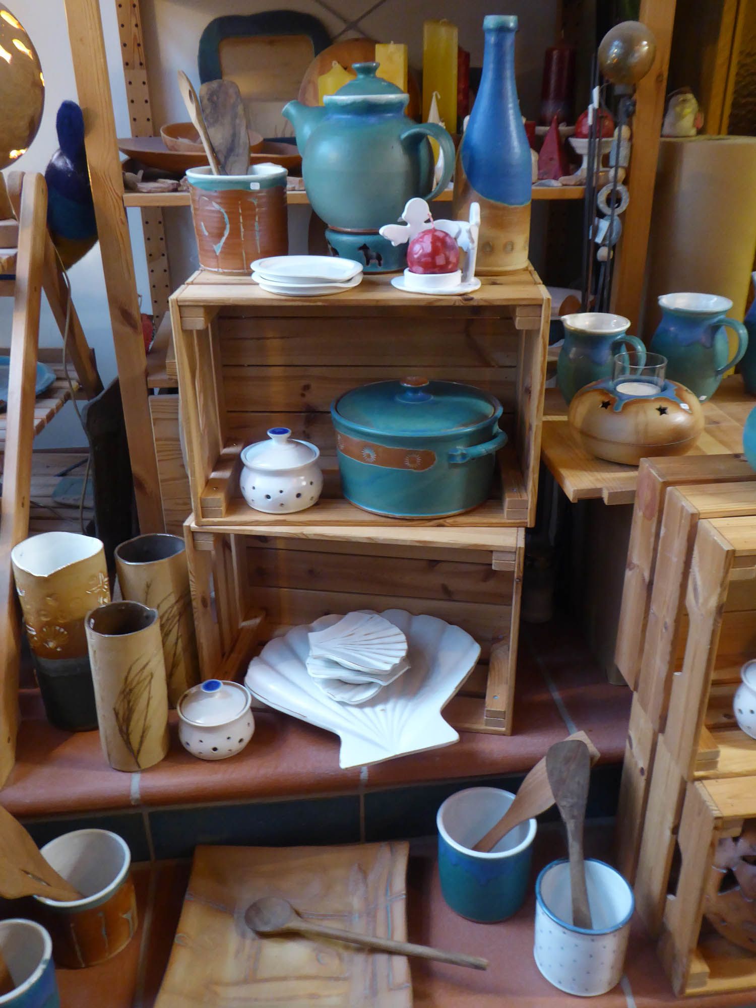 Ein Holzregal mit Töpfen und Pfannen darauf.