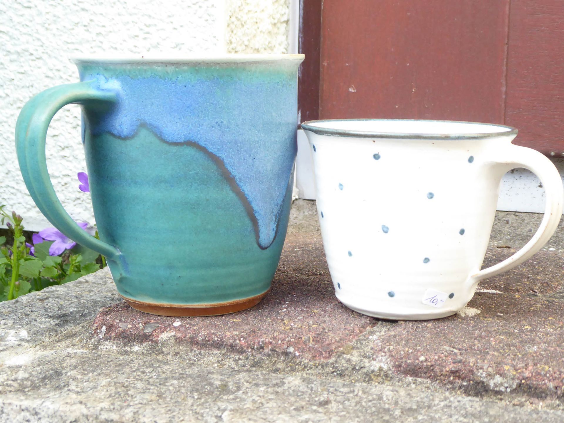 Zwei Tassen stehen nebeneinander auf einem Felsvorsprung