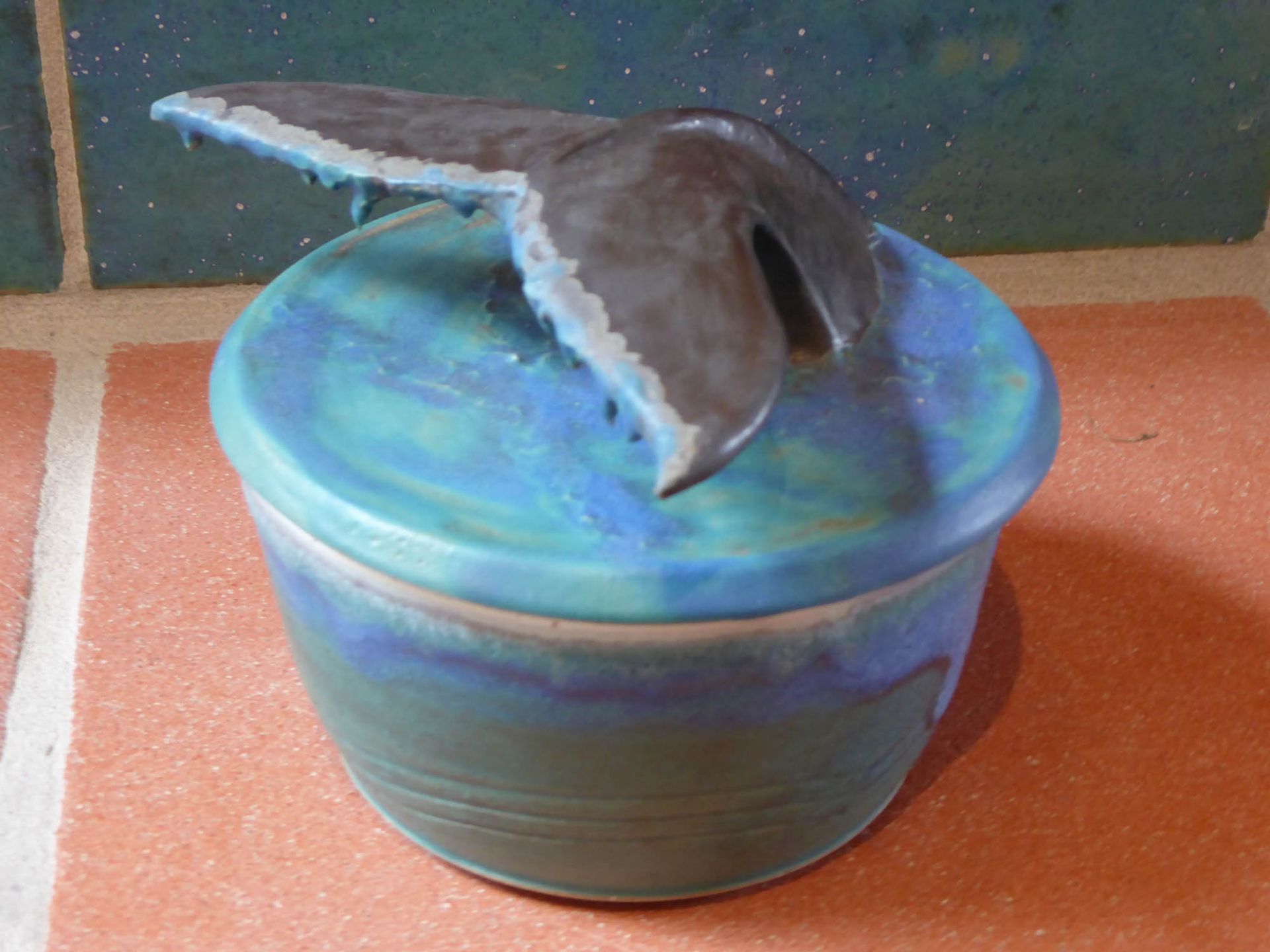 Eine blaue Schüssel mit einer Walflosse darauf