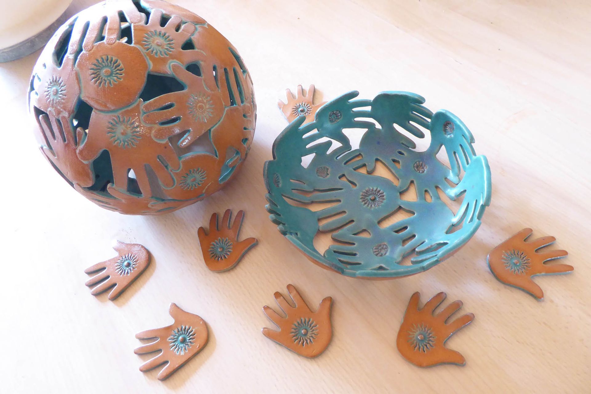 Eine Schale und ein Kerzenständer mit Händen darauf